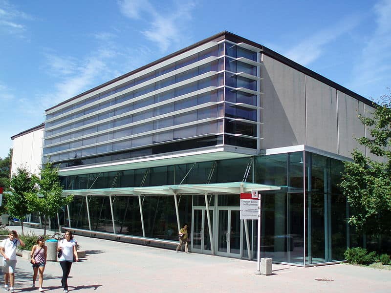 A modern engineering building on campus, with students walking past.