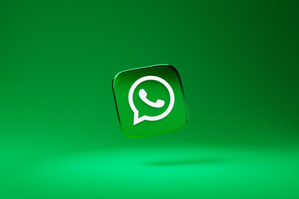 The WhatsApp app logo (which features a phone icon in a speech bubble) floating on a green backdrop