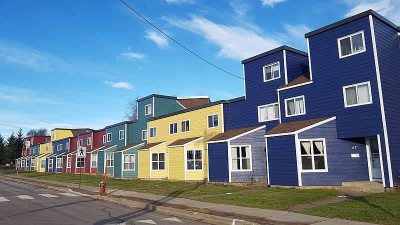 A row of colourful two- and three-storey homes along a mid-sized street in Moncton, New Brunswick.