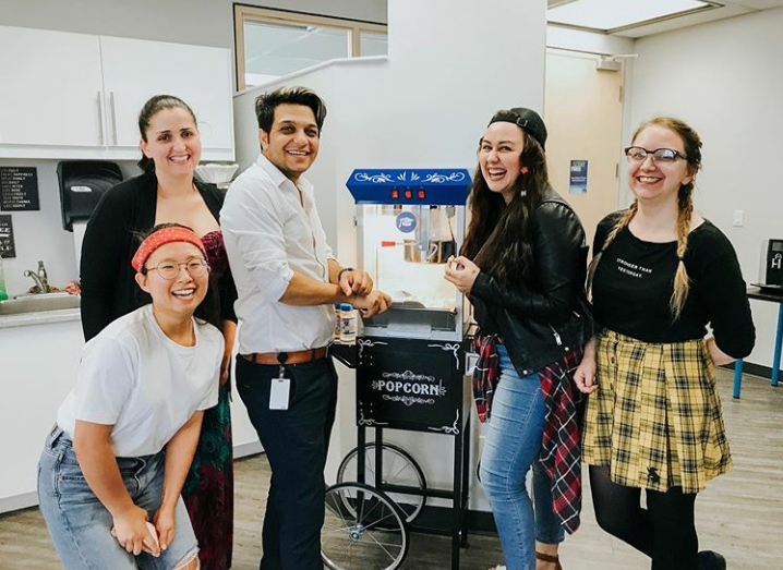 ApplyBoard staff posing by popcorn maker in kitchen