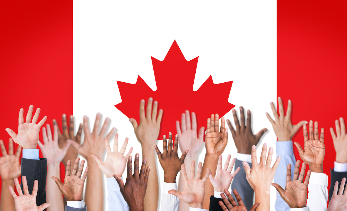 Canadian flag with many different hands infront of it