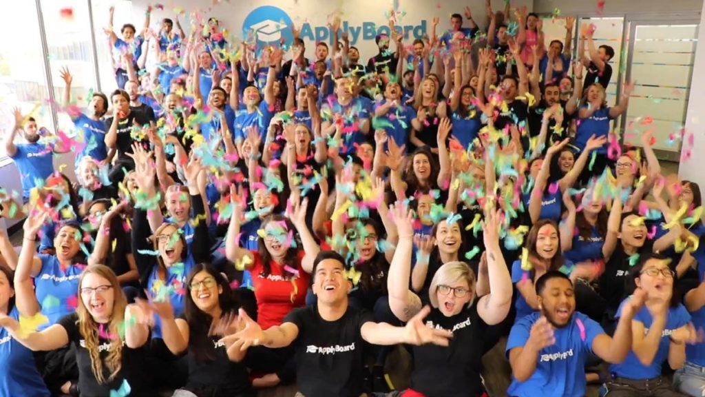 ApplyBoard employees with arms raised