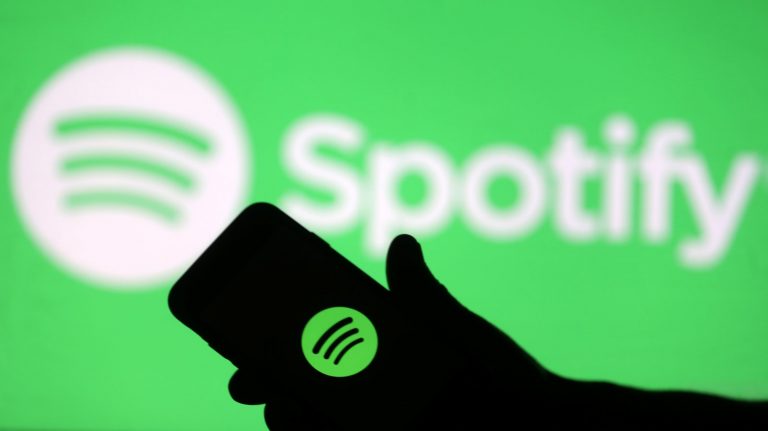 Handing holding phone with Spotify logo
