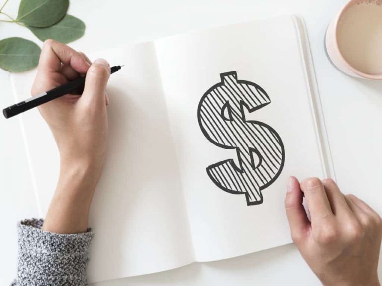 Woman doodling a money sign in journal
