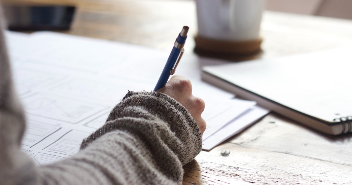 Person writing at table