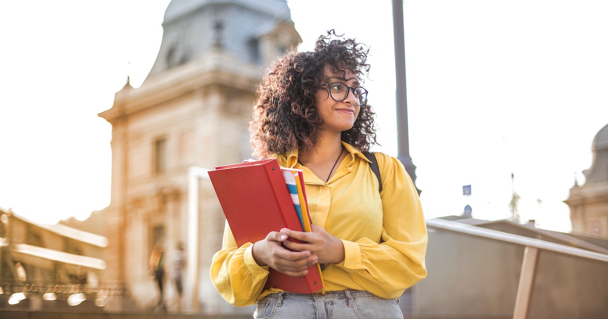 Estudiante sosteniendo libros de texto