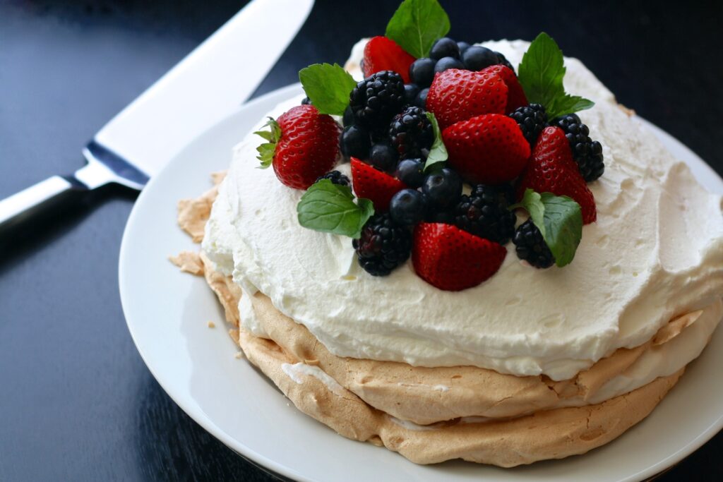 Australian food - A pavlova dessert with mixed berries and mint on top.