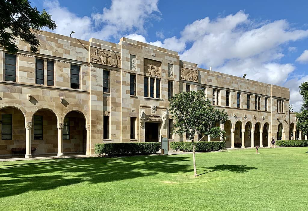 A classical sandstone two-storey building next to a landscaped green space. (Steele Building, University of Queensland)