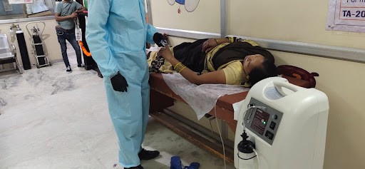 A photo of a lady laying on a stretcher in a hospital bed.