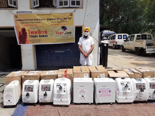 A photo of a man standing outside in front of a bunch of ventilators.