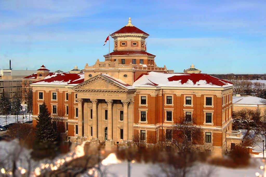 A tall brick building with snow on its roof (University of Manitoba)