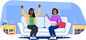 Two women sitting on a couch, one holding popcorn and the other with both hands in the air, cheering.