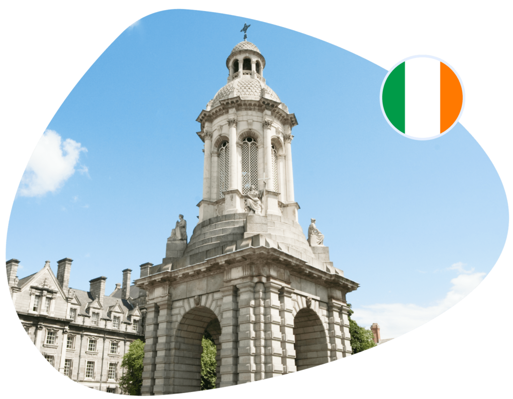 A white stone tower stands against a blue sky, with an Irish flag adjacent