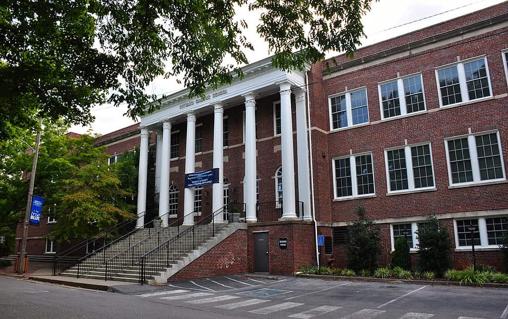 A three-storey red-brick building with Corinthian columns and a stairway leading to the front door. (MTSU Teachers College)