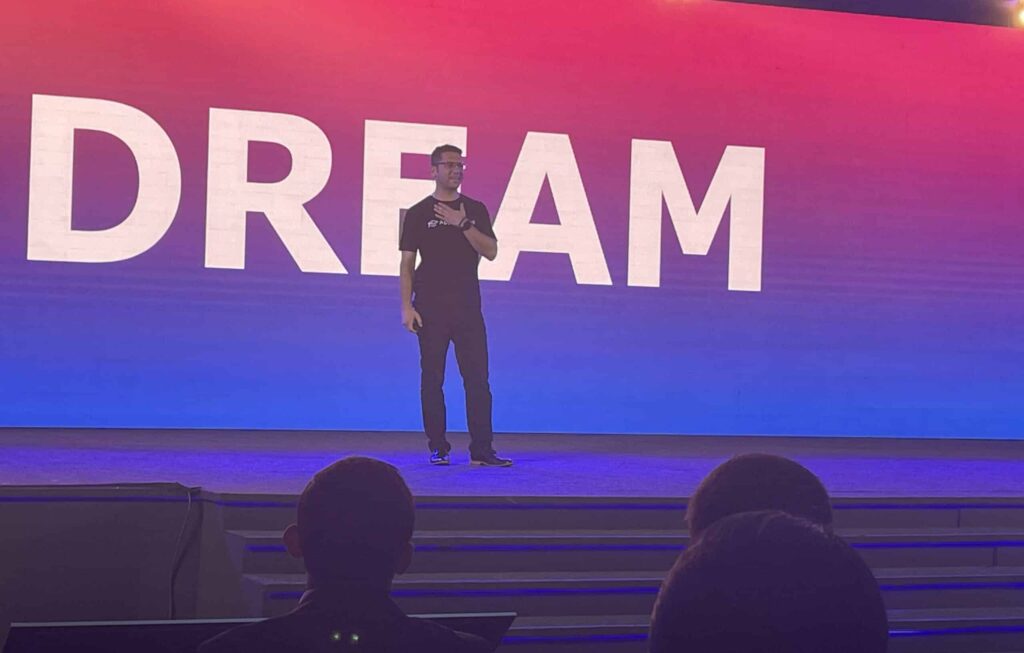 ApplyBoard Co-Founder and CEO Martin Basiri, on stage at TRW 2022, with the word "Dream" behind him in large letters.