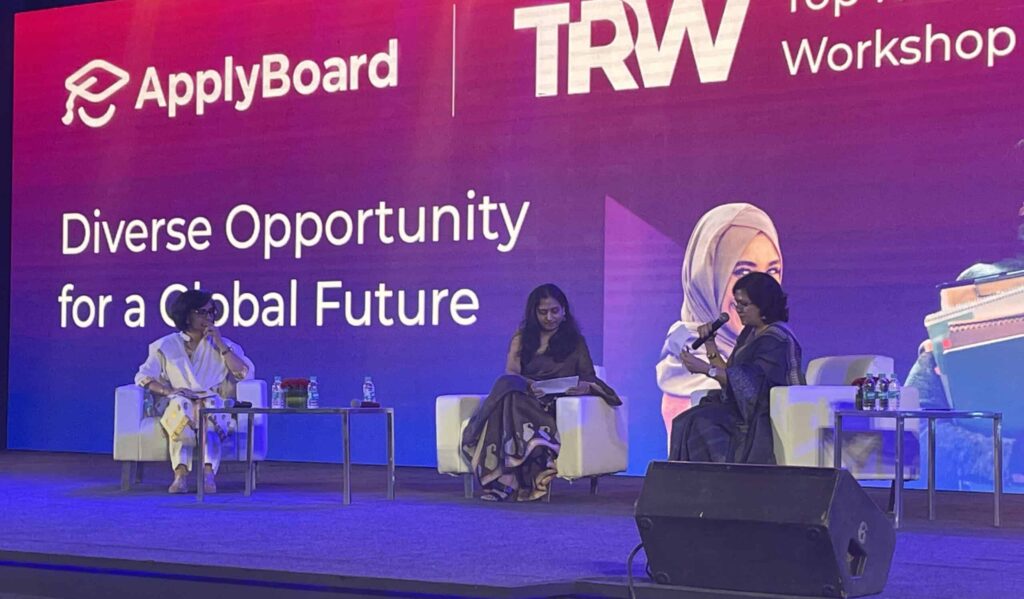 An image of a panel at TRW, with three guest speakers on stage discussing Diverse Opportunity for a Global Future.