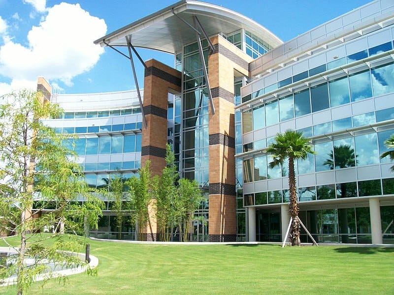 A multistorey modern building on a very green lawn, with a vaulted entry. (Engineering, UCF)