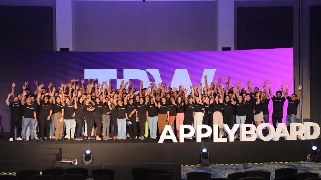 The ApplyBoard team in black shirts on stage at TRW South Asia 2023.