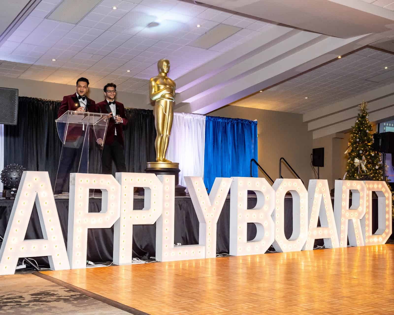 Photograph of Meti and Massi Basiri handing out ApplyBoard Core Values Awards