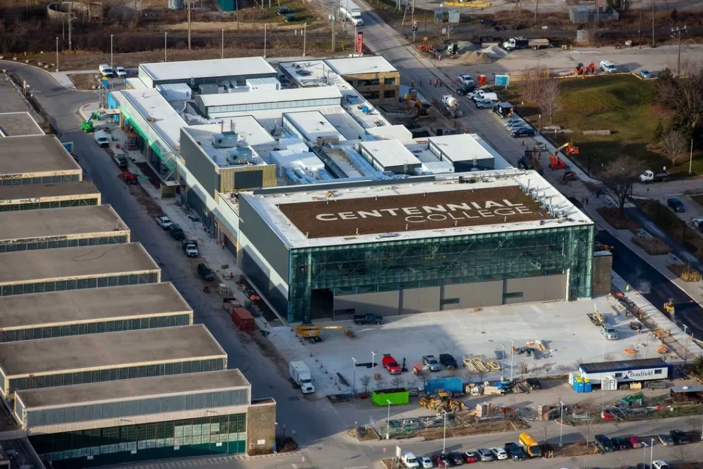 A photo of a Centennial College building with the college name visible in large letters on the roof.