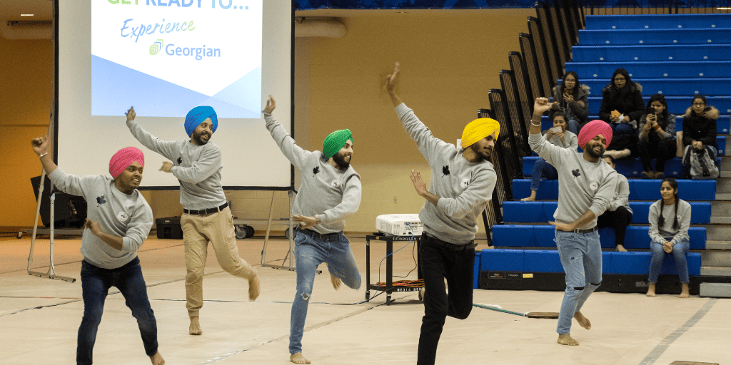 Five students, mid-dance, during Georgian College's International Orientation in 2019.