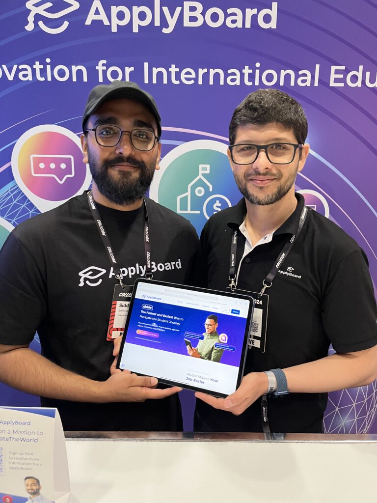 Photograph of two ApplyBoardians holding tablet showcasing Abbie, the first-ever AI study abroad advisor